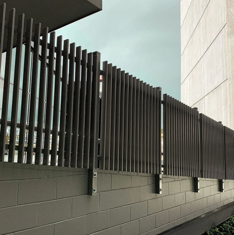 Black aluminium 50mm blade fence panels installed on a boundary wall